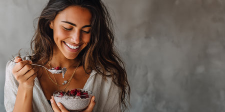 Young happy woman enjoying a refreshing chia pudding with berries for breakfast, embracing a healthy and balanced lifestyle, promoting wellness and nutritious eating habitsの素材