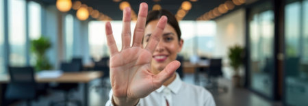 Businesswoman showing five fingers in a bright modern office, banner with copy space for textの素材