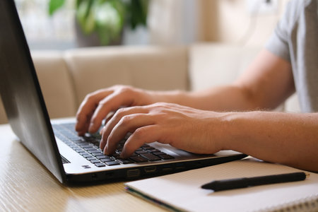 Freelancer hands typing on laptop keyboard