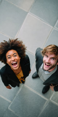 Diverse business professionals enthusiastically looking up, celebrating achievement, joy, and freedom in successful teamwork, expressing excitement and happiness in a moment of triumphの素材