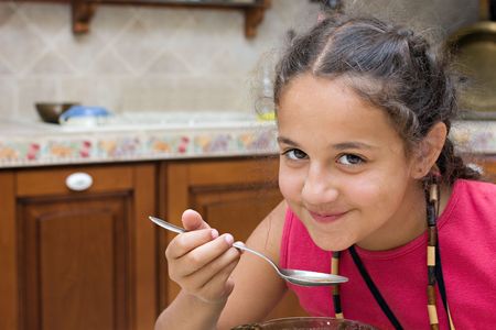Coquettish girl eating soup. の写真素材