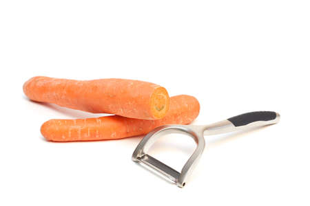 A carrot peeler and carrots isolated on a white background. の写真素材
