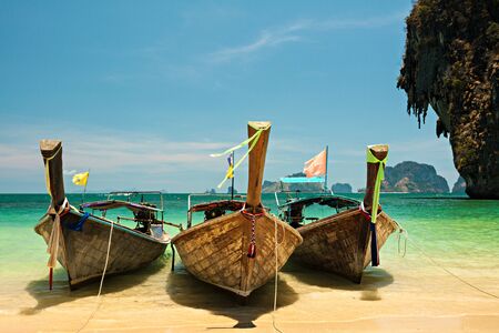 Tropical blue sea with boats, island and yellow beach.の写真素材