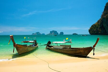 Beautiful amazing nature background. Tropical blue sea with boats and yellow beach.の写真素材
