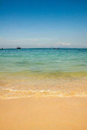 Beautiful amazing nature background. Tropical blue sea with boats and yellow beach.の写真素材