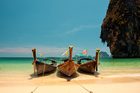 Tropical blue sea with boats, island and yellow beach.の写真素材