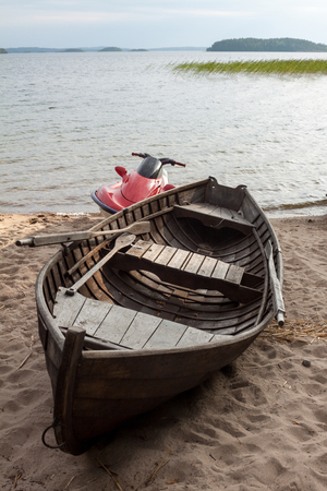 Lake with a wooden boat and hydrocycle in Finland.の写真素材
