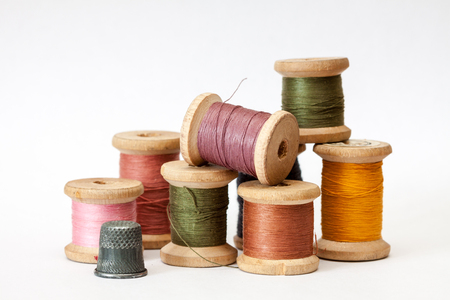 Old wooden coils of thread isolated on a white background.の写真素材