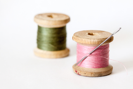 Old wooden coils of thread isolated on a white background.