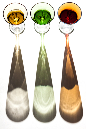 Multicolored glasses on a white background and interesting shadows.の写真素材