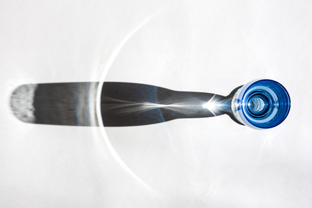 Blue glasse on a white background; interesting shadow and the place for the text.の写真素材