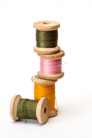 Old wooden coils of thread isolated on a white background.の写真素材