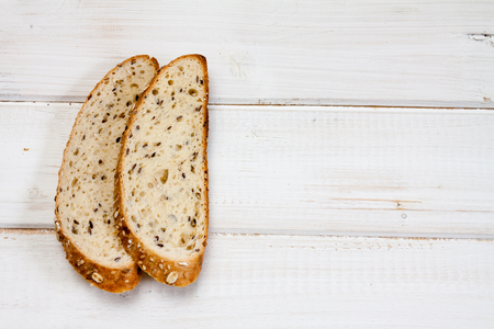 Top view of bread with different seeds on old wooden background.の写真素材