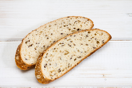 Top view of bread with different seeds on old wooden background.の写真素材