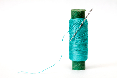 Old coil of cyan thread isolated on a white background.の写真素材