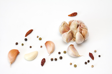 Raw garlic segments, pepper and red chillies on white background.の写真素材