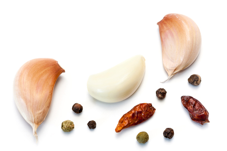 Raw garlic segments, pepper and red chillies isolated on white background.の写真素材