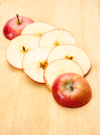 Slices of red apple on a wood background.の写真素材