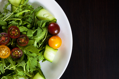 Plate with salad on a dark background. Space for text.の写真素材