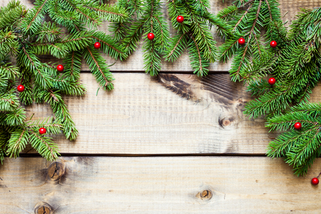 Wide Christmas border composed of fresh fir branches and ornaments in red on woodの写真素材