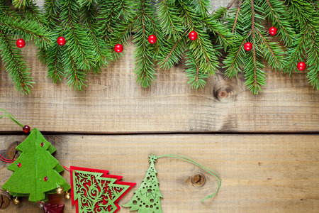 Wide Christmas border composed of fresh fir branches and ornaments in red on woodの写真素材