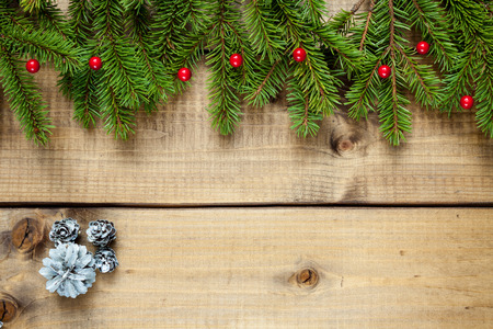Wide Christmas border composed of fresh fir branches and ornaments in red on woodの写真素材