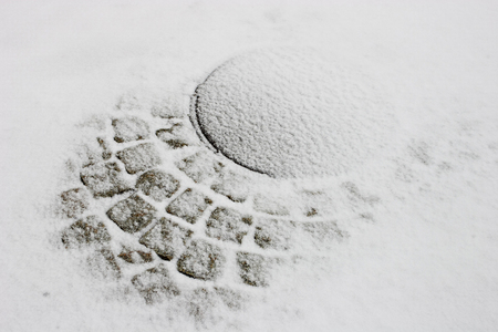 The manhole and pavement covered with snow.の写真素材