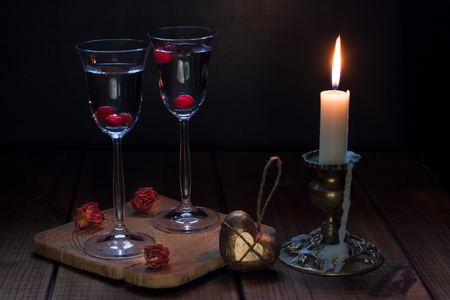 Still life with a candle and two glasses of red wine.の写真素材