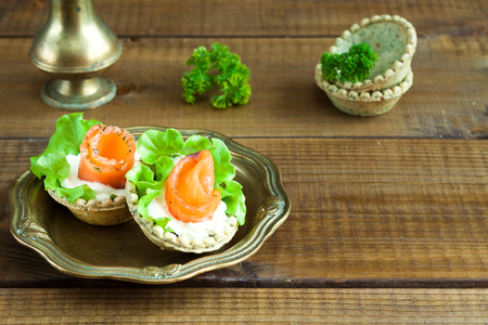Tartlets with salmon, cream cheese and salad on rustic woodの写真素材