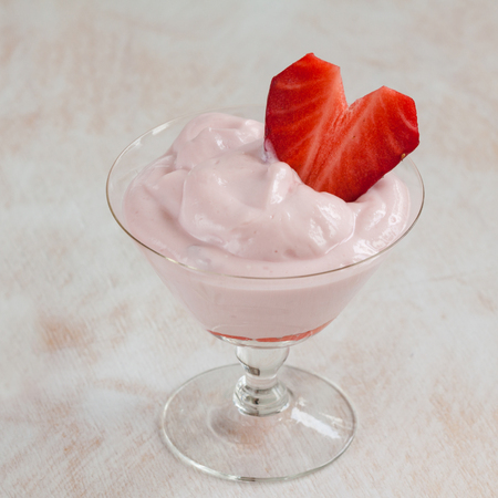 Milk dessert in a glass with strawberry heart.の写真素材