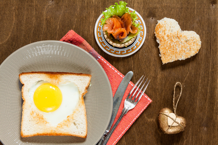 Breakfast with heart fried eggs and salmon tartlet.の写真素材