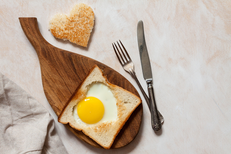 Breakfast with heart fried eggs on a board.の写真素材