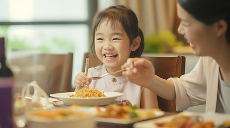 happy asian family mother and child daughter eating spaghetti together at homeの素材