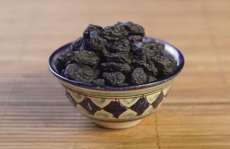 closeup of painted oriental dish with dry raisinsの写真素材