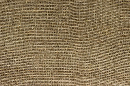 The structure of the threads of a natural burlap fabric close up.