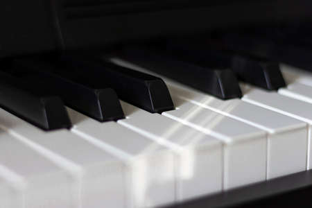 Black and white piano keys in dim lighting and shadows.の写真素材