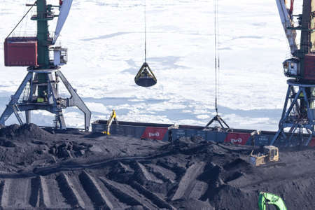 Vladivostok, Russia - January, 28, 2018: Transfer of coal from railway cars to a ship in the port of...