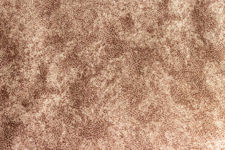 The texture of a dark brown dense fabric with a variegated pattern.