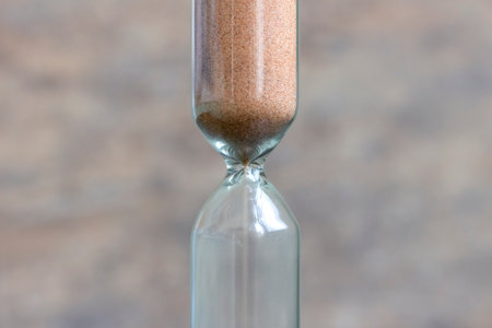 Sand pouring in an hourglass.の写真素材