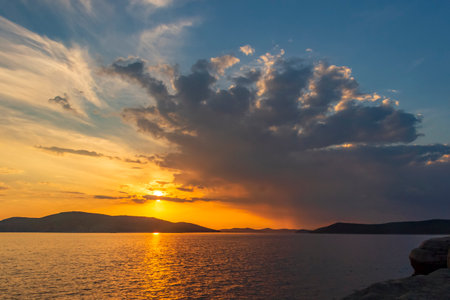 Picturesque sunset on the sea among the clouds on a summer evening.の写真素材