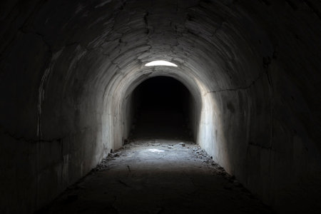 A sunlit exit from a dark dungeon. Light at the end of the tunnel, exit from the underground passage.の写真素材