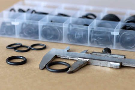 Measuring the diameter of the rubber O-ring with a caliper. An old measuring tool and a set of...