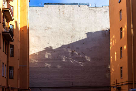 Exterior wall of a house with reflections of windows in an old courtyard in St. Petersburg.の写真素材