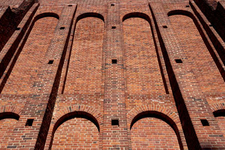A wide old brick wall with recesses and protruding parts.の写真素材