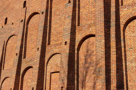 A wide old brick wall with recesses and protruding parts.の写真素材