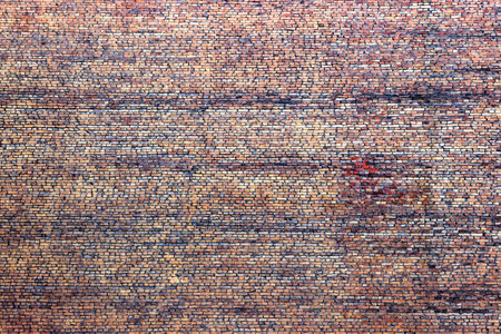 A huge solid brick wall with no windows. Old, cracked masonry, coated with deposits and grime.