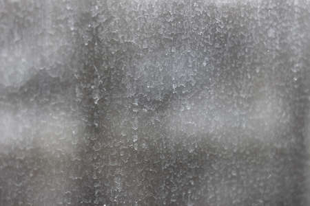 Streaks and traces of raindrops on the dirty window glass. Blurry and unfocused background.