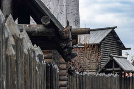 A protective palisade around a wooden log house in a Russian village. Traditional Russian construction of huts.の写真素材