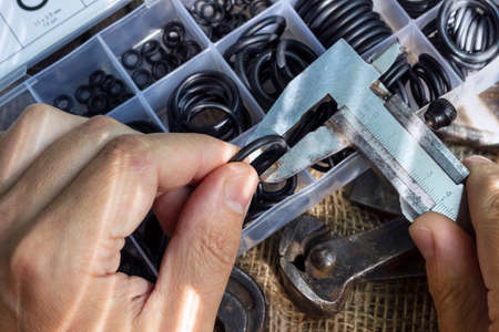 Measuring the diameter of the rubber ring with a caliper. A man is holding an old measuring...