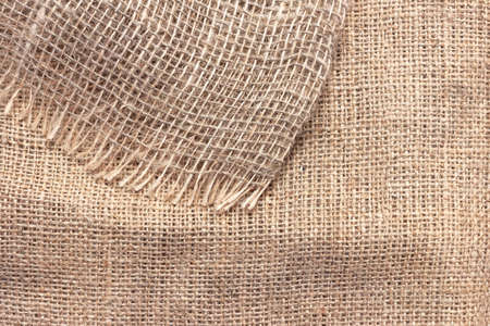 Natural burlap with large cells. The texture of a coarse woven fabric with mesh and fibers.